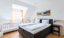 Schlafzimmer mit Doppelbett und Kinderbett