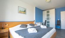 Das Schlafzimmer mit Doppelbett, Schreibtisch und Kleiderschrank