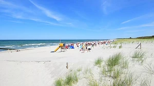 Breiter weißer Sandstrand, Strandkörbe und Klettergerüst