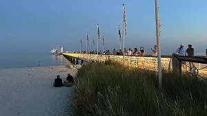 beleuchtete Seebrücke mit Tauchgondel und Fahrgastschiff